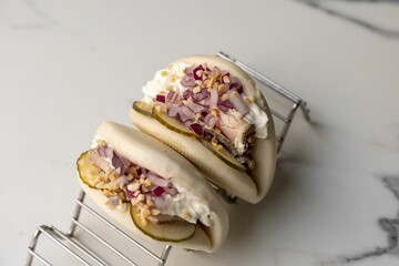 Steamed beef bao buns served with onions on the marble table