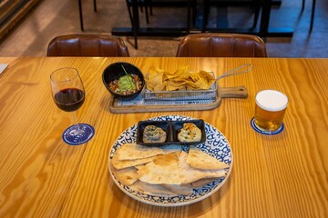 Sticker - Toasted tortilla, sauces, chips, salad and a glass of wine on a wooden table