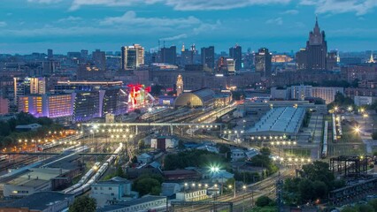 Wall Mural - Panoramic top view to Kiev Railway Station night to day transition timelapse and modern city in Moscow, Russia. Aerial rooftop view with trains and rail tracks. Illuminated buildings from above