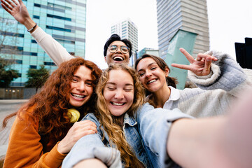 Young friends taking selfie picture with mobile phone outdoors in the modern city - Blond girl making self portrait of buddies