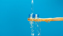 Bamboo Toothbrush Water Splash On Blue Background