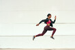 © Emil L/peopleimages.com - Woman, fitness and running jump action on mockup for cardio training, exercise or workout outdoors. Fit, active and sporty female person or runner exercising for health and wellness on mock up space