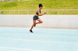 © Emil Lime/peopleimages.com - Woman, cardio and running on stadium track for training, physical exercise or workout. Active, fit or sporty female person, athlete or runner in sports run, race or competition for healthy wellness