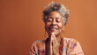 A peaceful afro senior woman poses in prayer for her studio shot. Generative AI