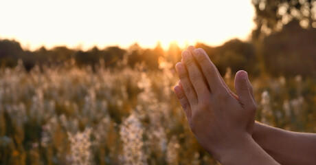 man's palms in pray and worship against sunny natural blurred background. Blessing, Repent, Help, hope, faith, devotion of God. symbol Belief in God. Religion, spirituality concept. copy space