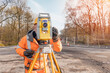 © Iryna - Site engineer operating his instrument during roadworks. Builder using total positioning station tachymeter on construction site for new road setting out