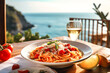 canvas print picture - Spaghettiteller mit Weinglas in Italien mit Meerblick