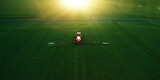Fototapeta  - Tractor spraying pesticides on wheat  field with sprayer  in spring.