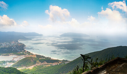 a peaceful Con Dao island, Vietnam, view from Thanh Gia mountain. Coastal view with waves, coastline, clear sky and road, blue sea and mountain.