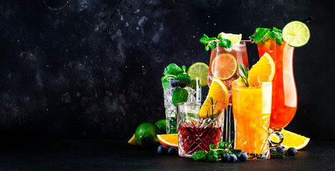 Wall Mural - Popular summer cocktail drinks set: negroni, blueberry mojito, screwdriver, hurricane and french mule on black bar counter background, copy space banner