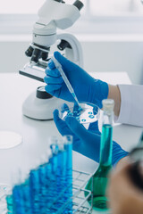 medical or scientific researcher researching and experimenting multi-colored solution, vial and micr