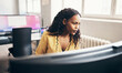 © Flamingo Images - Young businesswoman working on a computer at her office desk