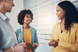 © Flamingo Images - Three diverse businesswomen smiling while talking in an office