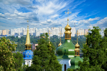 City landscape with ancient Vydubitsky Monastery, river Dnieper and modern high-rise buildings in Kyiv