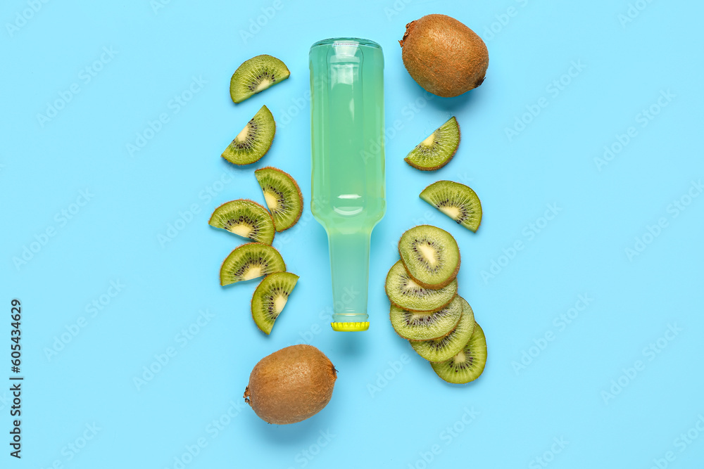 Composition with bottle of fresh soda and kiwi on blue background