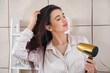 © Pixel-Shot - Pretty young woman with hair dryer in bathroom