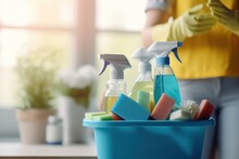 cropped cleaning woman with a bucket and various cleaning supplies on a blurred background