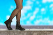 Close up of female legs in black leather chelsea boots and black tights. Footwear fashion concept.