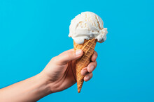 hand holding a waffle cone with white ice cream on a blue background, Generative AI