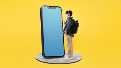 Student Guy Touching Smartphone Blank Screen On Yellow Studio Background