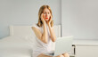 © rohappy - Portrait of tired young woman with headache worked with laptop on the bed in white room at home