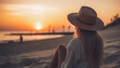 © PasAI Photography - A young beautiful girl with a hat is sitting on the hot sand on the beach and looking at the sunrise. Minimal summer romantic scene