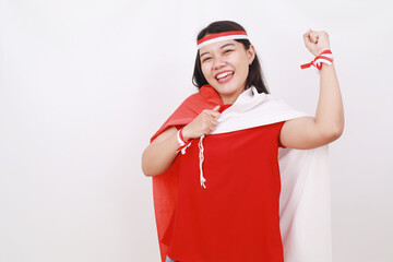 Cheerful young indonesian girl celebrate independence day while holding red white flag and fist hand