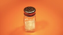 Modern Salt Shaker With Metal Cap On Orange Background
