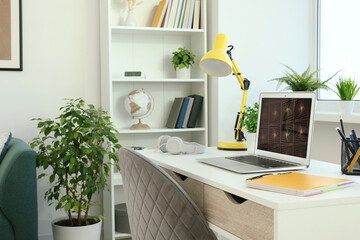 Cozy workspace with laptop on white wooden desk at home