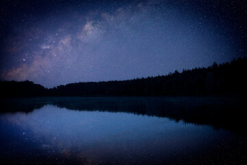 Wall Mural - Amazing starry sky and trees reflecting in lake at night