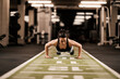 © dusanpetkovic1 - A strong sportswoman is doing pushups in a gym.