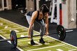 © Dusan Petkovic - A muscular sportswoman in shape is lifting barbell in a gym.