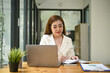 © bongkarn - Beautiful and focused Asian businesswoman writing something on report