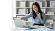© crizzystudio - copy space, panorama ,banner Modern working lifestyle, asian businesswoman showing happy gesture of online business success on laptop and mobile phone using internet happily in office.