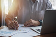 © khunkornStudio - Businessperson report graph analysis marketing and paperwork chart finance investment strategy with laptop computer.