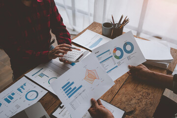 Wall Mural - Team work process, business team using calculator to calculate figures of business statistics, profit, growth rate graph document. information charts on the office desk.