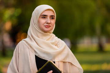 Wall Mural - Portrait of a young Muslim woman in hijab outdoor.