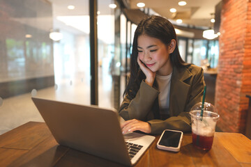 Happy business freelance asian woman using laptop computer at cafe urban lifestyle