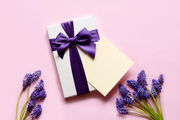 Canvas Print - Flat lay composition with muscari flowers, gift box and envelope mockup with blank greeting card on light background. Minimal floral frame. Happy mother's day, women's day, birthday or wedding.