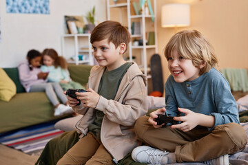 Wall Mural - Portrait of two excited boys playing videogames together, copy space