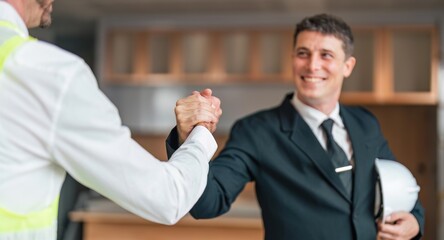 Wall Mural - Happy young civil engineer manager and architects handshaking at construction site and looking to next construction phase , cooperation teamwork concept