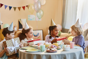 Wall Mural - Diverse group of happy children opening presents at Birthday party