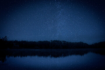 Wall Mural - Amazing starry sky and trees reflecting in lake at night