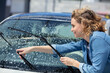 © auremar - happy woman cleaning the car window