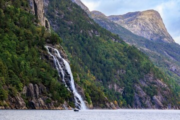 Wall Mural - Scenic view of a waterfall cascading down the rocks in a rural area in daylight