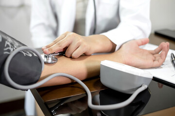 The female doctor measured blood pressure, the patient examined the heartbeat and sat down to talk about health care closely. health care concept