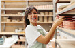 © (JLco) Julia Amaral - Young female ceramist smiling at the camera in her shop