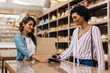 © (JLco) Julia Amaral - Female customer making an NFC payment in a ceramic store