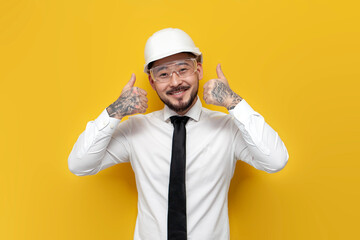 Wall Mural - asian foreman in shirt with tie showing likes over yellow isolated background, korean civil engineer in formal wear