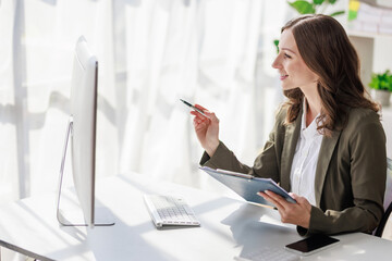 Concept of business office woman working,Businesswoman smile while working about her invesment plan with analyzing document and business investment graph data by using laptop on desk in workstation.